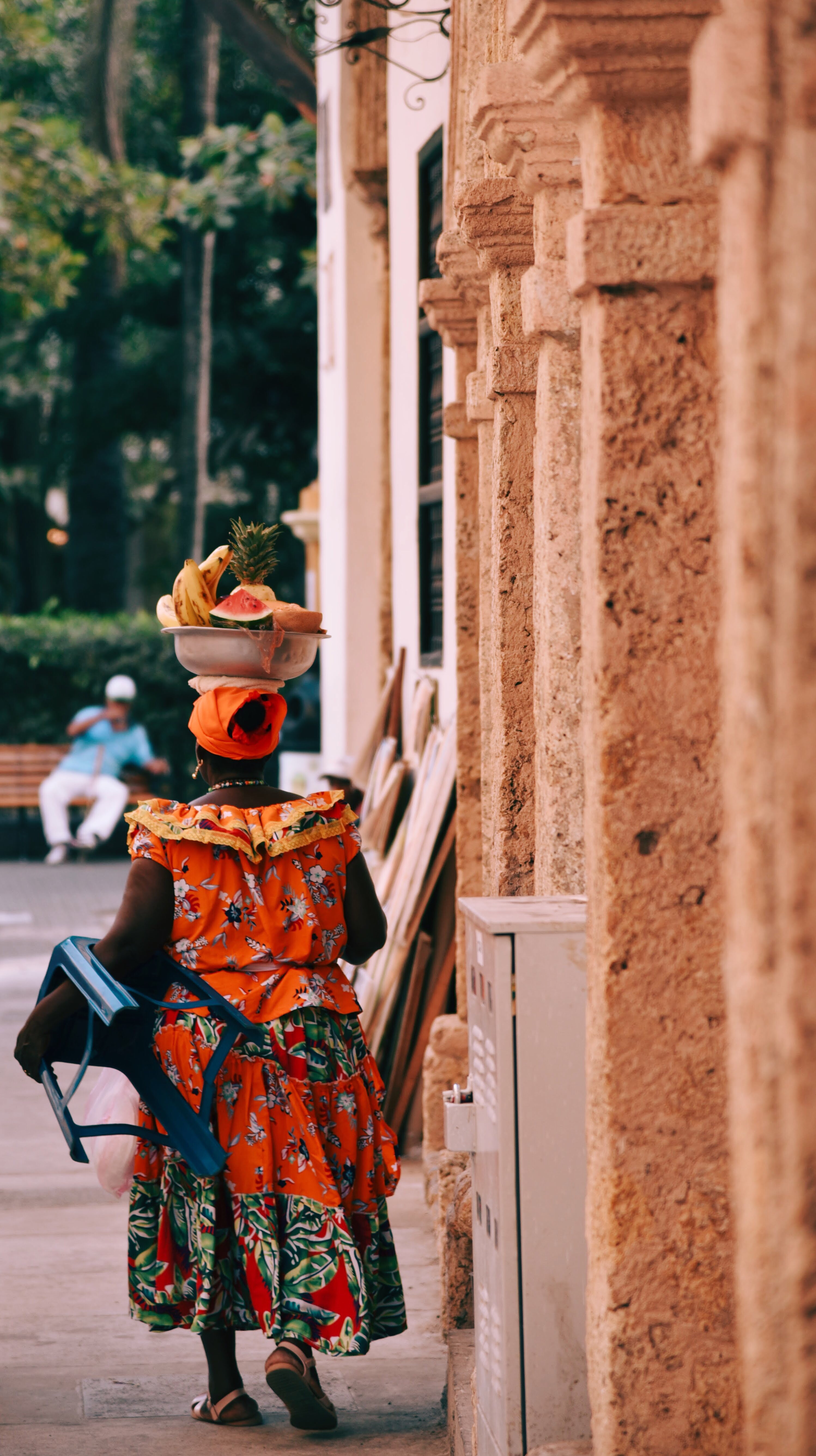 A woman carrying a basket of fruit.