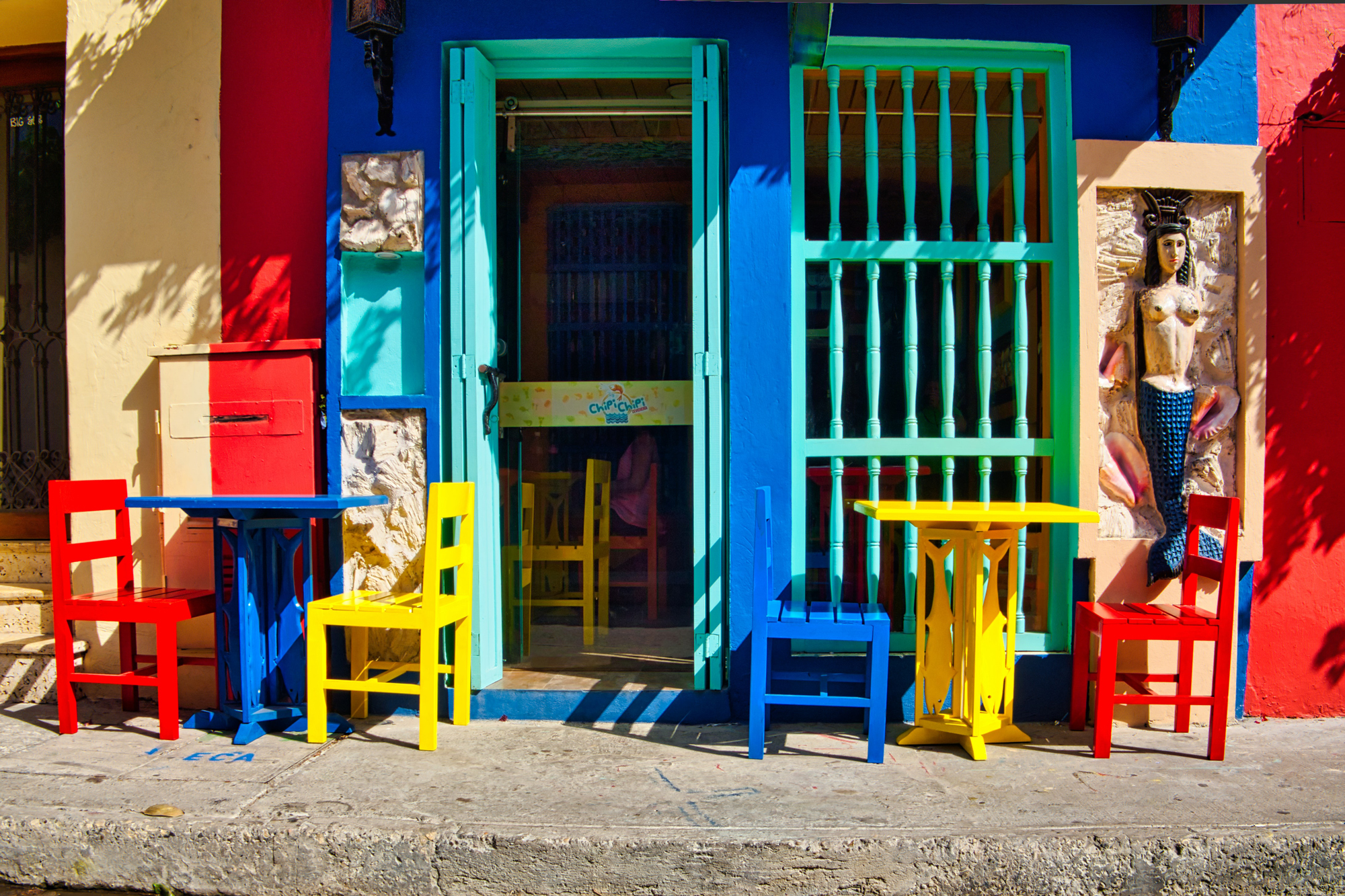 Brightly colored chairs outside of a business.